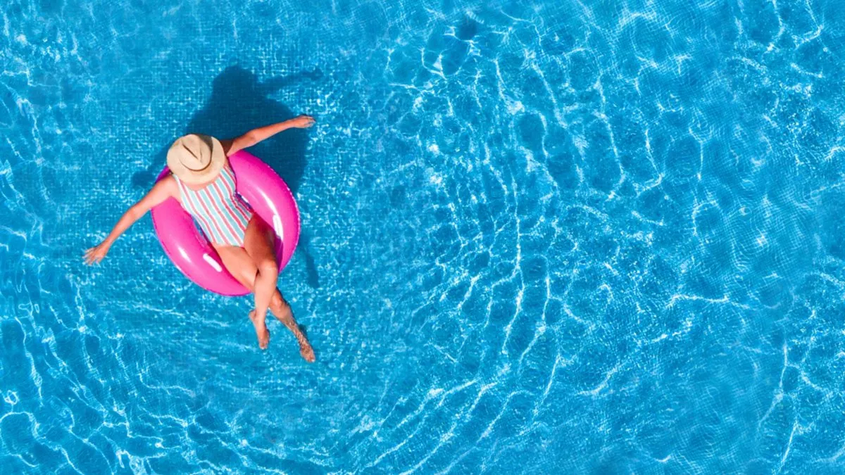 Pessoa em uma boia rosa numa piscina azul, imagem usada pela Accor na página da campanha