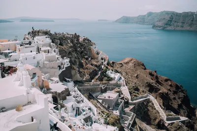 Casas brancas de Oia em encosta acima do mar em Santorini